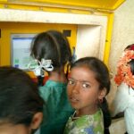 Sugata Mitra's hole-in-the-wall experiment; some children using a computer embedded into a wall.